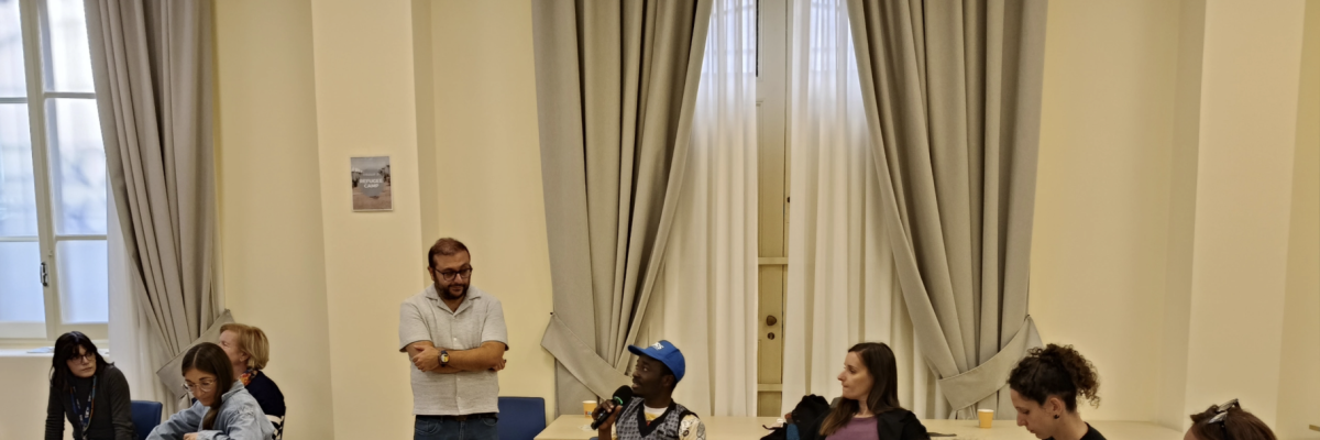 JRS IO staff and partners participating in A Journey Into Exile simulation in Rome. This session was conducted by JRS Canada's Tevfik Karatop. A group of adults sitting around in a circle havinga discussion.